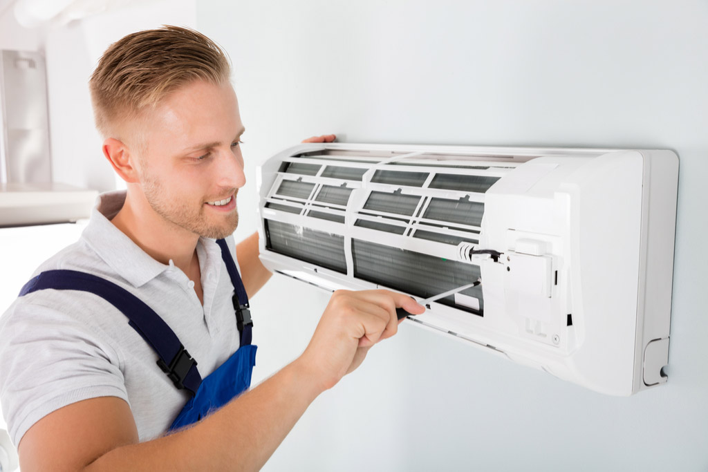 HVAC technician performing ductless air conditioning maintenance in Syracuse
