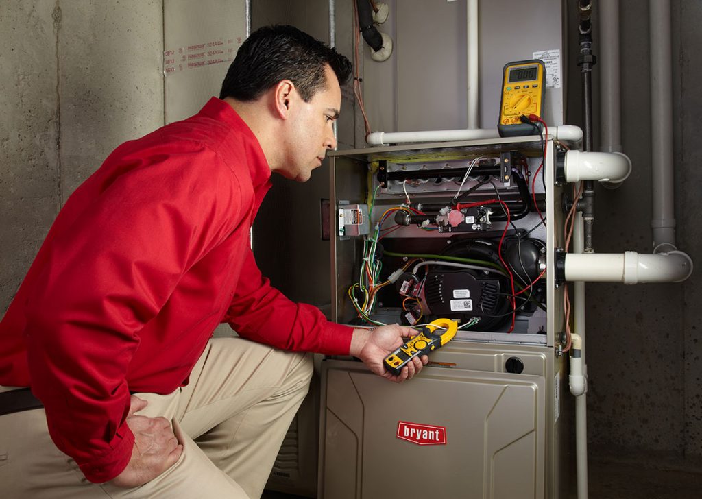 HVAC technician repairing an indoor furnace in Syracuse