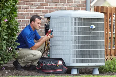 design-air-heating-and-air-conditioning-decatur-il-05 – Copy HVAC technician inspecting an outdoor air conditioning unit in Syracuse, UT