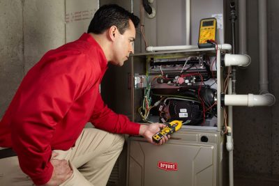 furnace repair Heating and air conditioning technician servicing an indoor furnace in Syracuse, UT